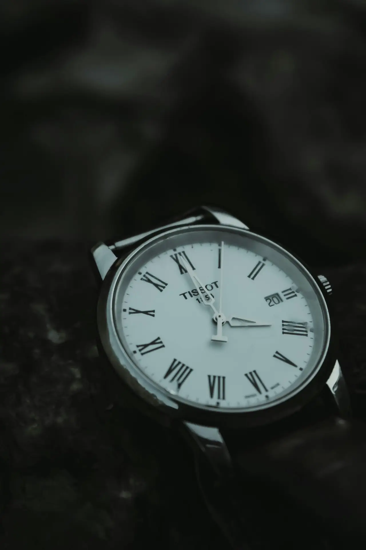 Close-up shot of a classic Tissot analog watch, showcasing its elegant clock face with Roman numerals.